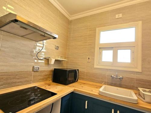 a kitchen with a sink and a microwave at Our home Our heaven in Madinaty