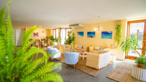 a living room with white furniture and plants at Hotel Costa Paradiso in Costa Paradiso
