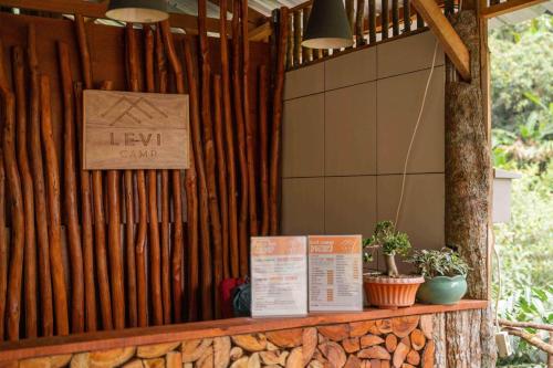 a sign on a wooden fence with plants on a counter at Levi Camp in Brujul