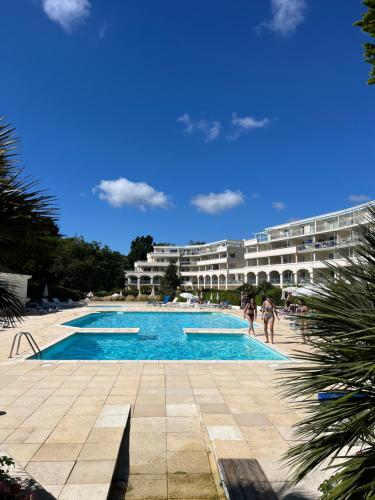 une piscine en face d'un grand bâtiment dans l'établissement Charmant appartement dans résidence de standing, à La Baule