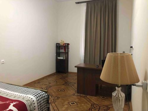 Zimmer mit einem Bett, einem Schreibtisch und einer Lampe in der Unterkunft Pikrisgora-luxury in Tbilisi City