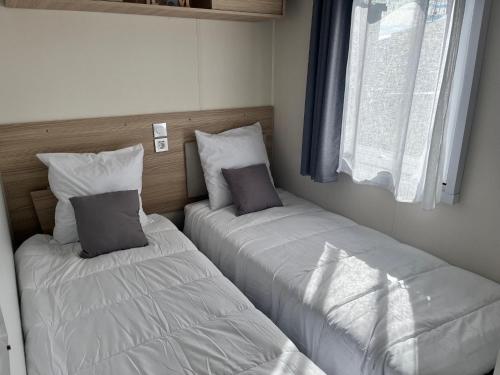deux lits côte à côte dans une pièce dans l'établissement Mobil Home CasaLuca 3 chambres 2 Salles d'eau, à Canet