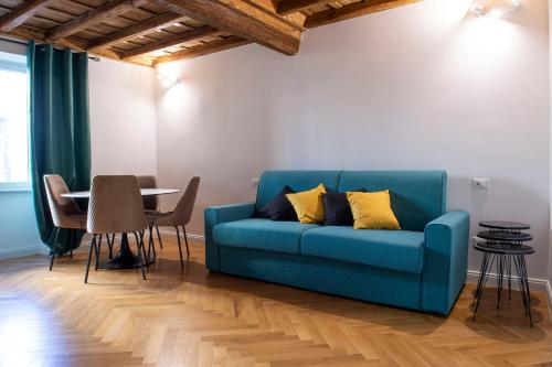a blue couch in a living room with a table at Costaguti Holiday Apartment in Rome