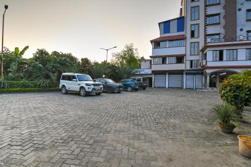 a parking lot with cars parked next to a building at Hotel Nilachal in mayapur