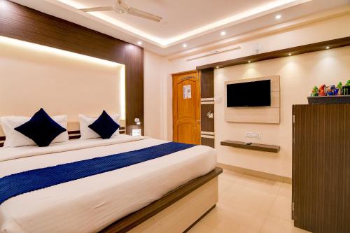 a bedroom with a large bed and a flat screen tv at Hotel Nilachal in mayapur