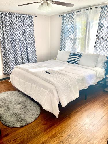 a large bed in a bedroom with blue and white curtains at Conveniently located spacious 3br Bush tavern in Birmingham