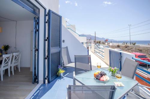a balcony with a table and a view of the beach at Casa Hortencia - Beautiful seaside apartment - Puerto de Las Nieves in Agaete