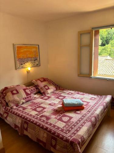 - une chambre avec un lit doté d'une couverture rose et d'une fenêtre dans l'établissement Holiday home in Axat, à Axat