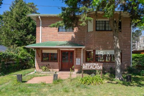 a brick building with a sign in front of it at Hosteria Recalada in Pinamar