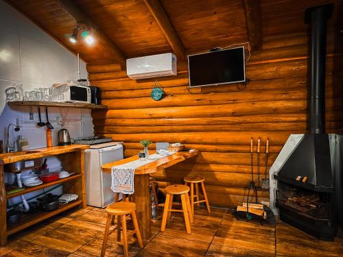 a kitchen with a stove and a table and stools at Refúgio do Caracol Pipas e Chalés in Canela