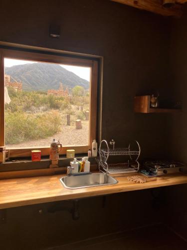 a kitchen counter with a sink and a window at Bendita Piedra Suites, Las Compuertas Lujan de Cuyo in Ciudad Lujan de Cuyo
