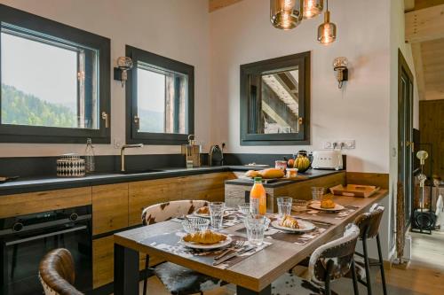 une cuisine avec une table avec de la nourriture dessus dans l'établissement Hameau des Cornuts - Apartment B06, aux Gets