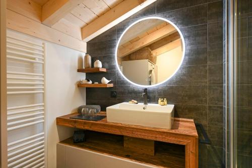 une salle de bain avec un lavabo et un miroir dans l'établissement Hameau des Cornuts - Apartment B06, aux Gets
