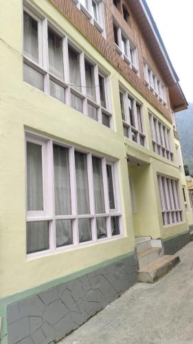 a yellow building with windows on the side of it at New snow view resort pahalgam in Pahalgām