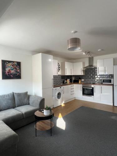 a living room with a couch and a kitchen at The Nook - Town Centre Apartment in Hoddesdon