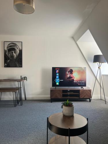 a living room with a tv and a table at The Nook - Town Centre Apartment in Hoddesdon