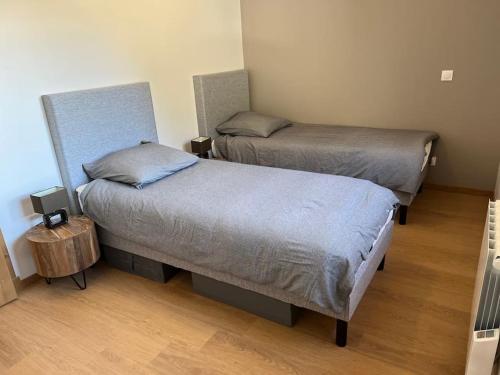 deux lits jumeaux dans une chambre avec parquet dans l'établissement Ski in and ski out in Oz, Alpe d'Huez, à Oz