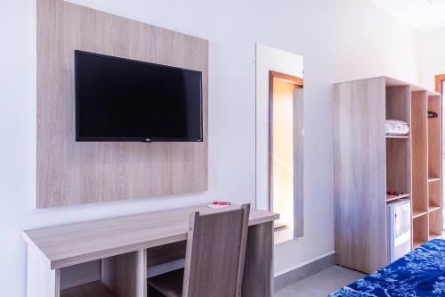a room with a flat screen tv on a wall at Pousada Piri Paim in Pirenópolis