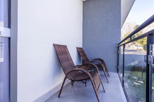 two chairs sitting on the balcony of a house at Pousada Piri Paim in Pirenópolis