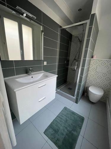 une salle de bain avec un lavabo, des toilettes et un miroir dans l'établissement L'épée Dieppoise by Holidieppe, à Dieppe