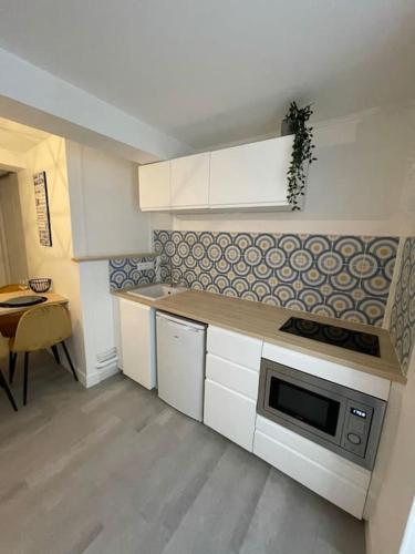 une petite cuisine avec un comptoir et un micro-ondes dans l'établissement L'épée Dieppoise by Holidieppe, à Dieppe