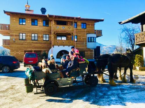 a group of people riding in a horse drawn carriage at Das Kitz - Chalet Steuerberg XL Kitzbühel in Kitzbühel