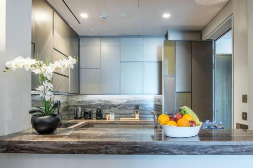Una cocina con un bol de fruta en la encimera. en FIRST CLASS 1BR Amazing Marina Views, en Dubái