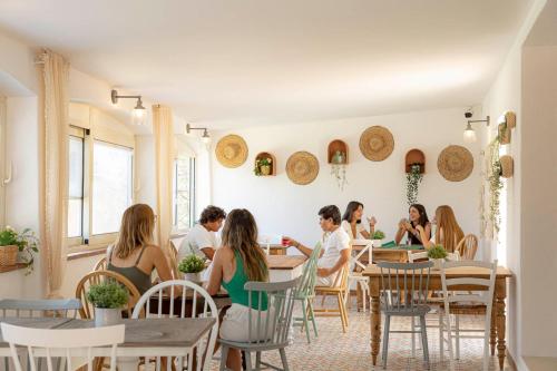 un groupe de personnes assises à des tables dans un restaurant dans l'établissement Corsica Hostel Porto Vecchio - partie chambre privée, à Porto-Vecchio