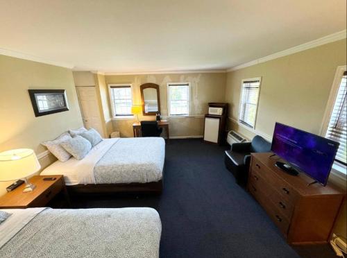 a hotel room with two beds and a flat screen tv at Kiteville Lancaster in Strasburg
