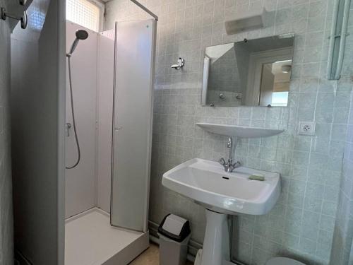 une salle de bain avec un lavabo et une douche dans l'établissement Appartement T3 chaleureux au centre de Cauterets, 4 couchages, balcon sud, proche thermes et télécabine - FR-1-234-132, à Cauterets