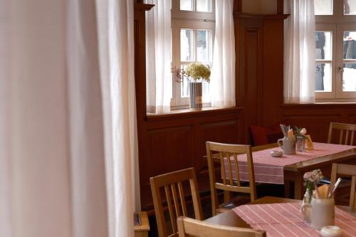 a dining room with two tables and two windows at Hotel Gasthof zum Ochsen in Ehingen