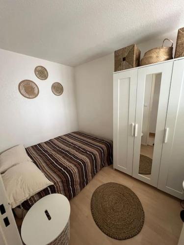 une petite chambre avec un lit et un miroir dans l'établissement T2 avec loggia à 10 min du centre de Montpellier, à Montpellier