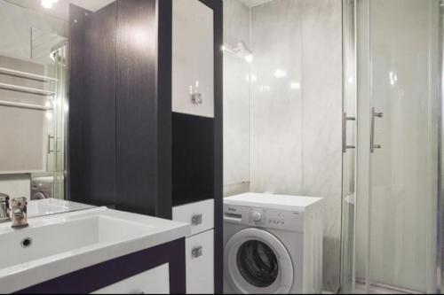 une salle de bain avec une machine à laver et un lavabo dans l'établissement T2 avec loggia à 10 min du centre de Montpellier, à Montpellier