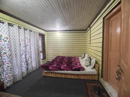 a bed in a room with a door and curtains at New snow view resort pahalgam in Pahalgām