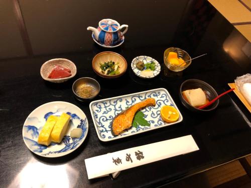 a black table with plates of food on it at Yadoya Kikokuso in Kyoto