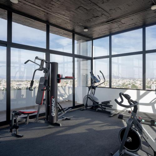 a gym with two exercise bikes in a room with windows at Departamento 2 habitaciones en la Americana in Guadalajara