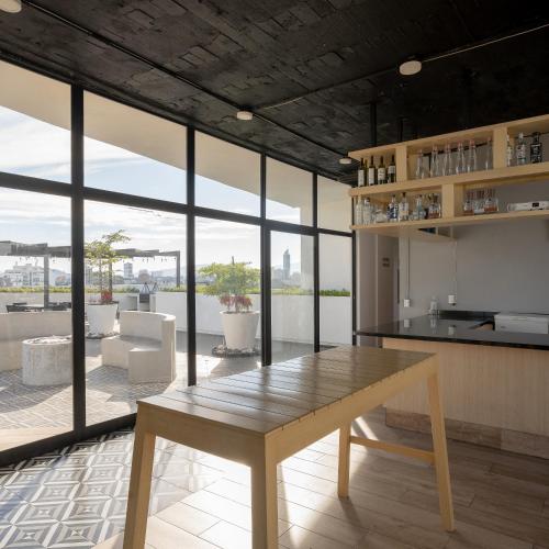 a living room with a wooden table and a kitchen at Departamento 2 habitaciones en la Americana in Guadalajara