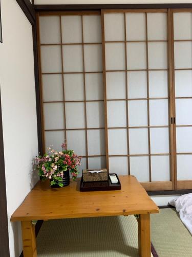 a room with a table with flowers on it at guest house REST in Kubogayato