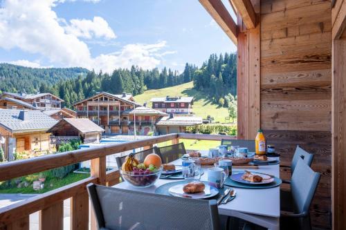 - une table de petit-déjeuner sur un balcon avec vue dans l'établissement Apartment Hogolyo, aux Gets
