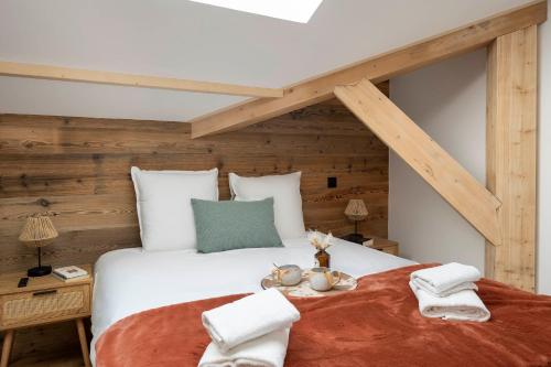 - une chambre avec un grand lit blanc et des murs en bois dans l'établissement Apartment Hogolyo, aux Gets