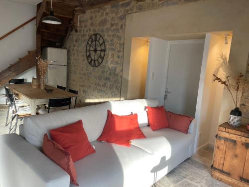 a living room with a white couch with red pillows at Gîte bourguignon premium in Semur-en-Auxois