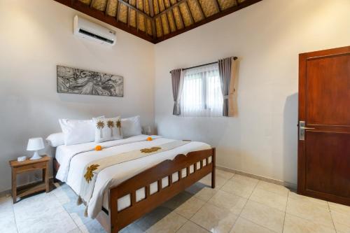 a bedroom with a large bed and a window at Villa Simara in Seminyak