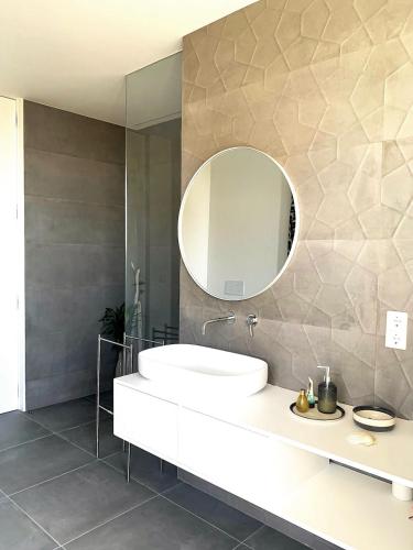 a bathroom with a white sink and a mirror at Villa Mar & Luz, Porto, Mindelo Beach in Mindelo