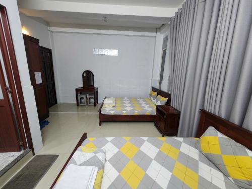 a small room with two beds and a window at Kathy Hotel in Ho Chi Minh City