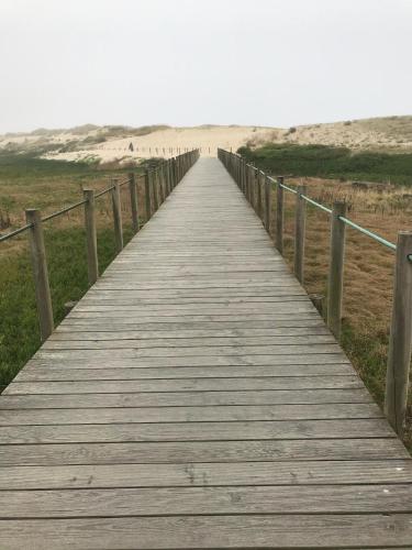 a wooden boardwalk leading down to the beach at Villa Mar & Luz, Porto, Mindelo Beach in Mindelo