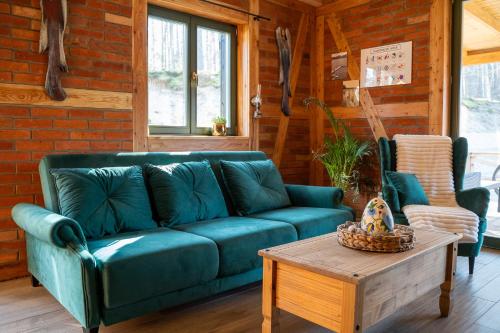 a living room with a blue couch and a coffee table at Domek Na Gwizdowce u PAWLAKA - KASZUBY in Sierakowice