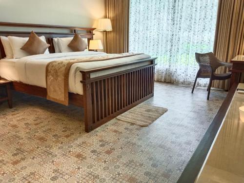 a hotel room with a bed and a window at UVA Sands Beach Resort in Kundapur