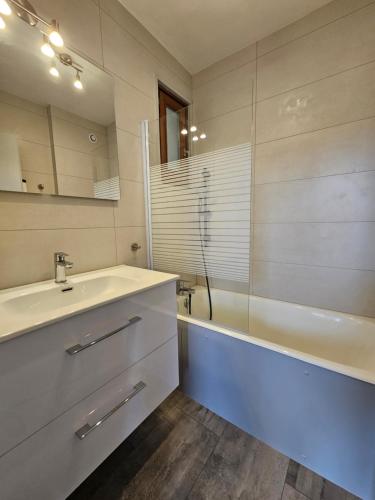 a bathroom with a sink and a shower and a tub at Pontarlier le Sympa ! 400m de la gare - Ma Petite Résa in Pontarlier