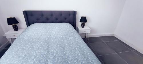 une chambre avec un lit et deux tables de nuit avec lampes dans l'établissement Charmant T2 à 5 min des Plages -10min Calanques, à Marseille