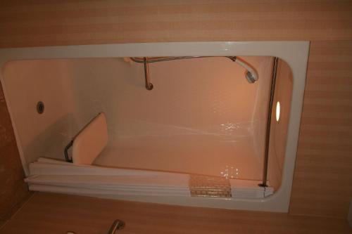 a bath tub with a shower in a room at Hampton Inn Clarksville in Clarksville